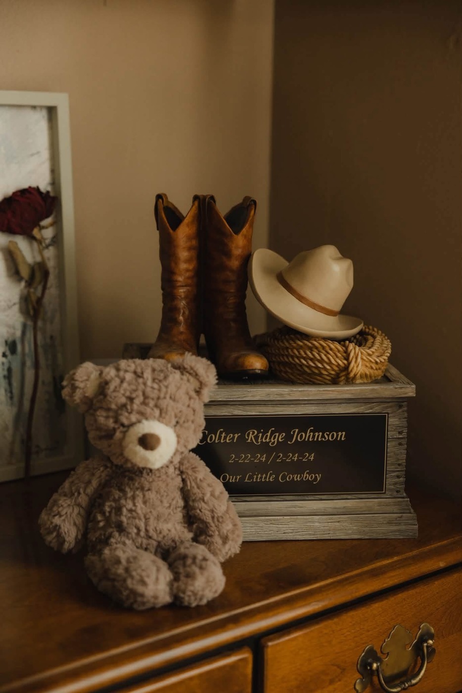 Colter’s remembrance display with his name, a teddy bear, cowboy boots, hat, and rope