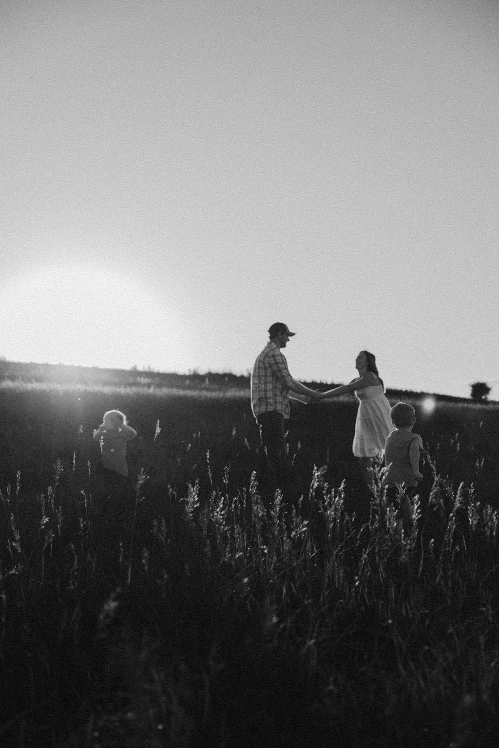 Black and white family photograph in a field at sunset