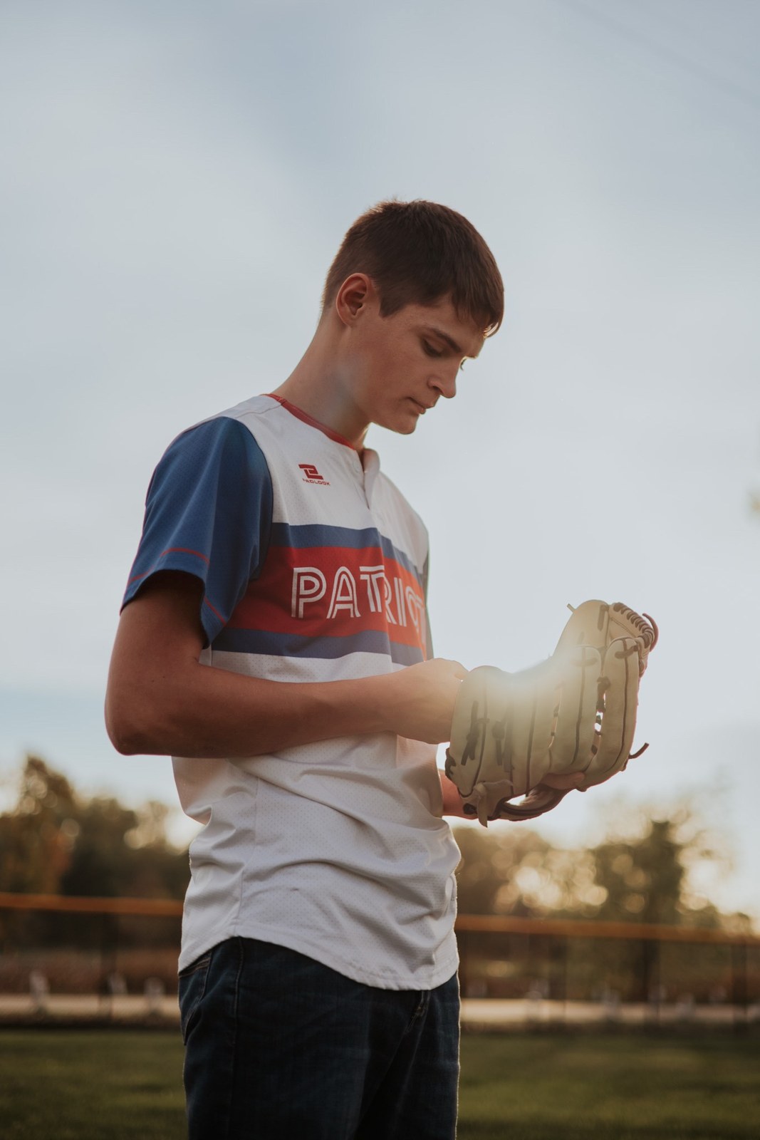Senior with a baseball glove at sunset