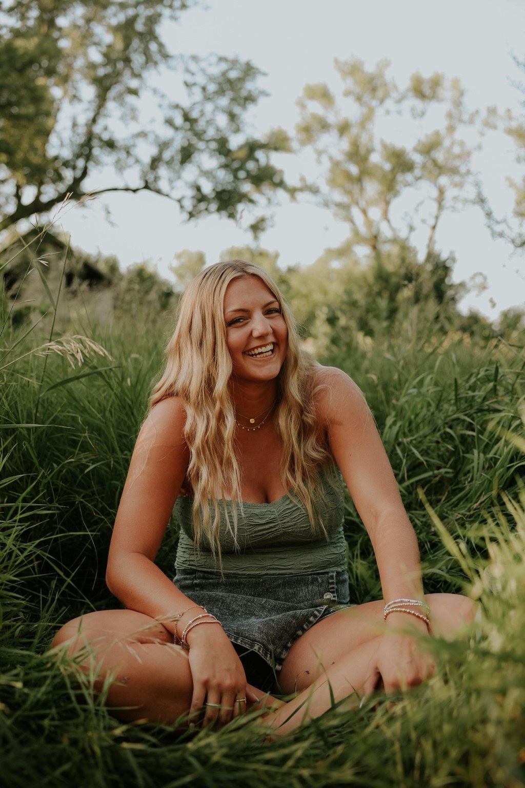 Senior smiling beneath a willow tree