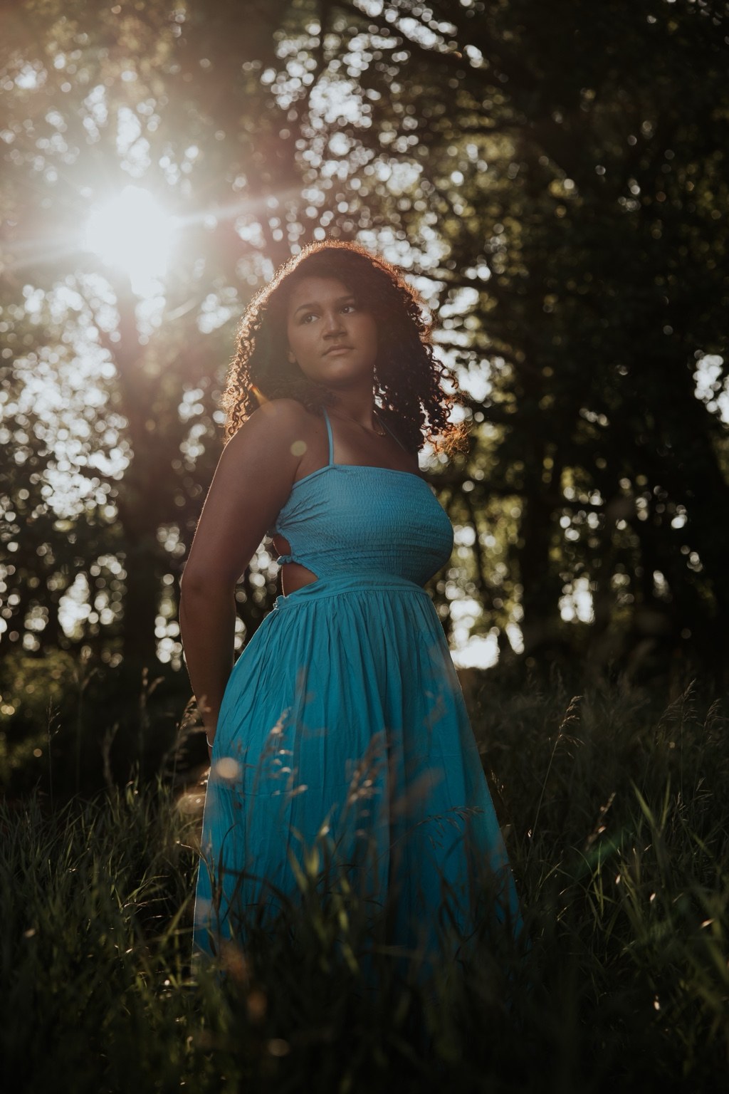 Senior in a turquoise dress beneath trees