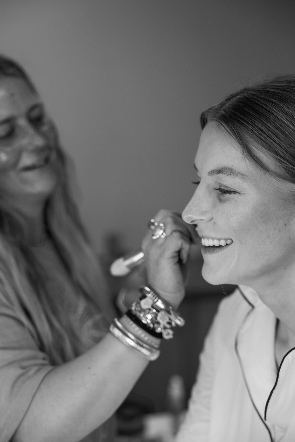 Black and white portrait of a bride having her makeup done