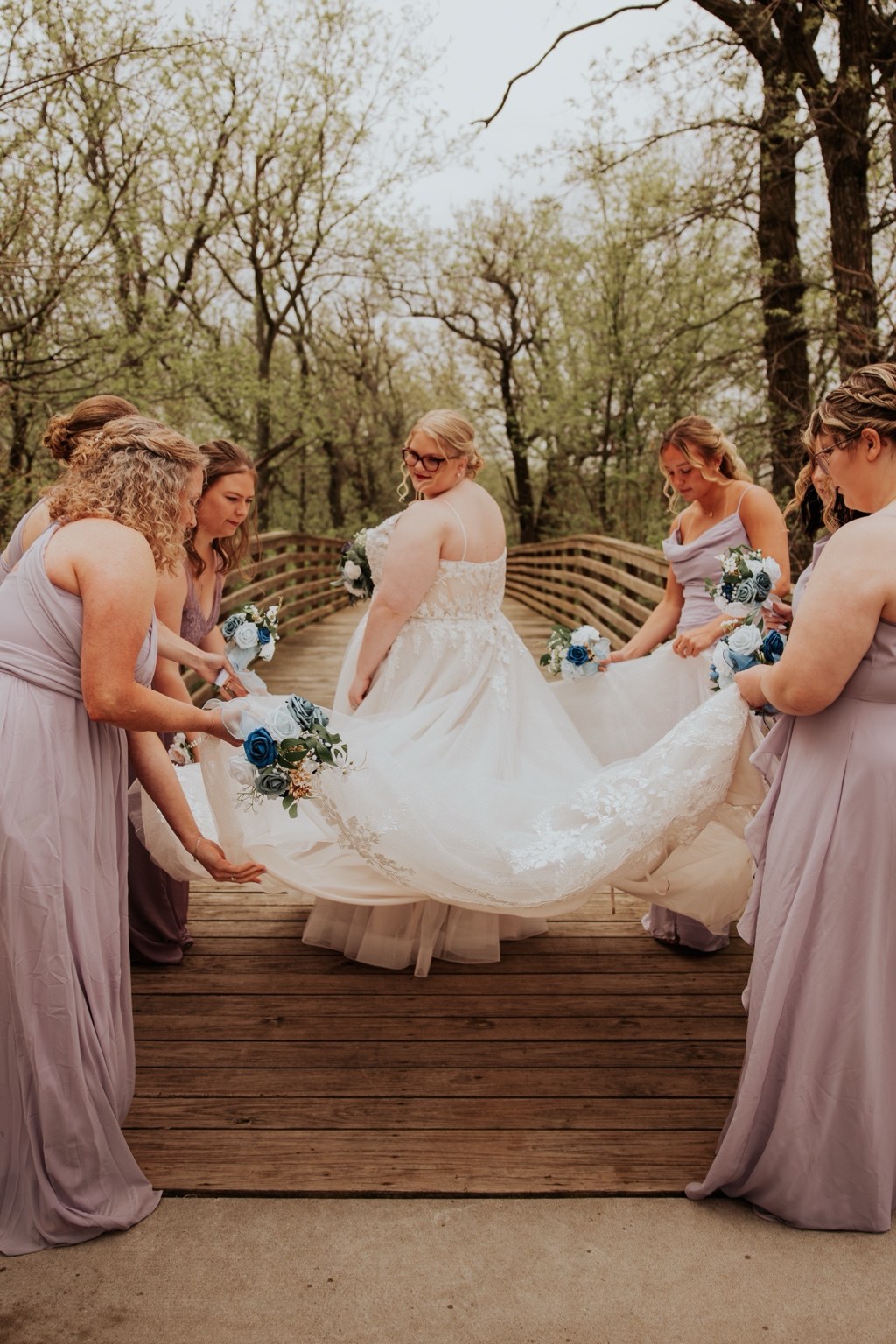 A bride with her bridesmaids on a wooden bridge