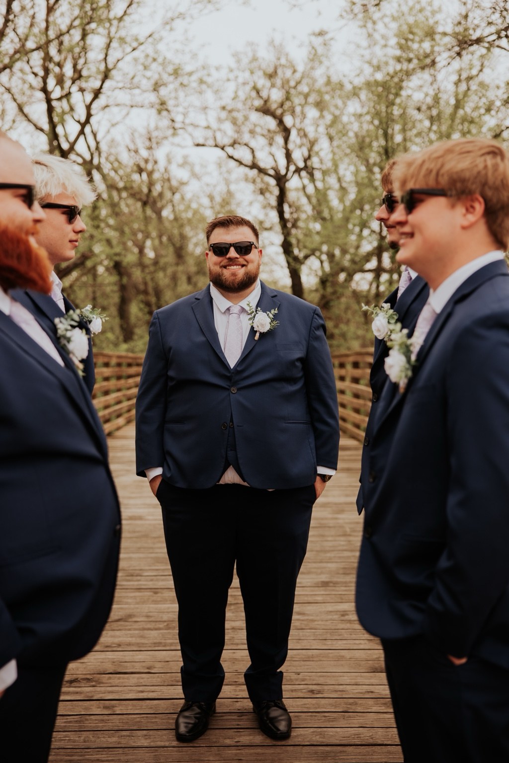 The groom smiling among his groomsmen