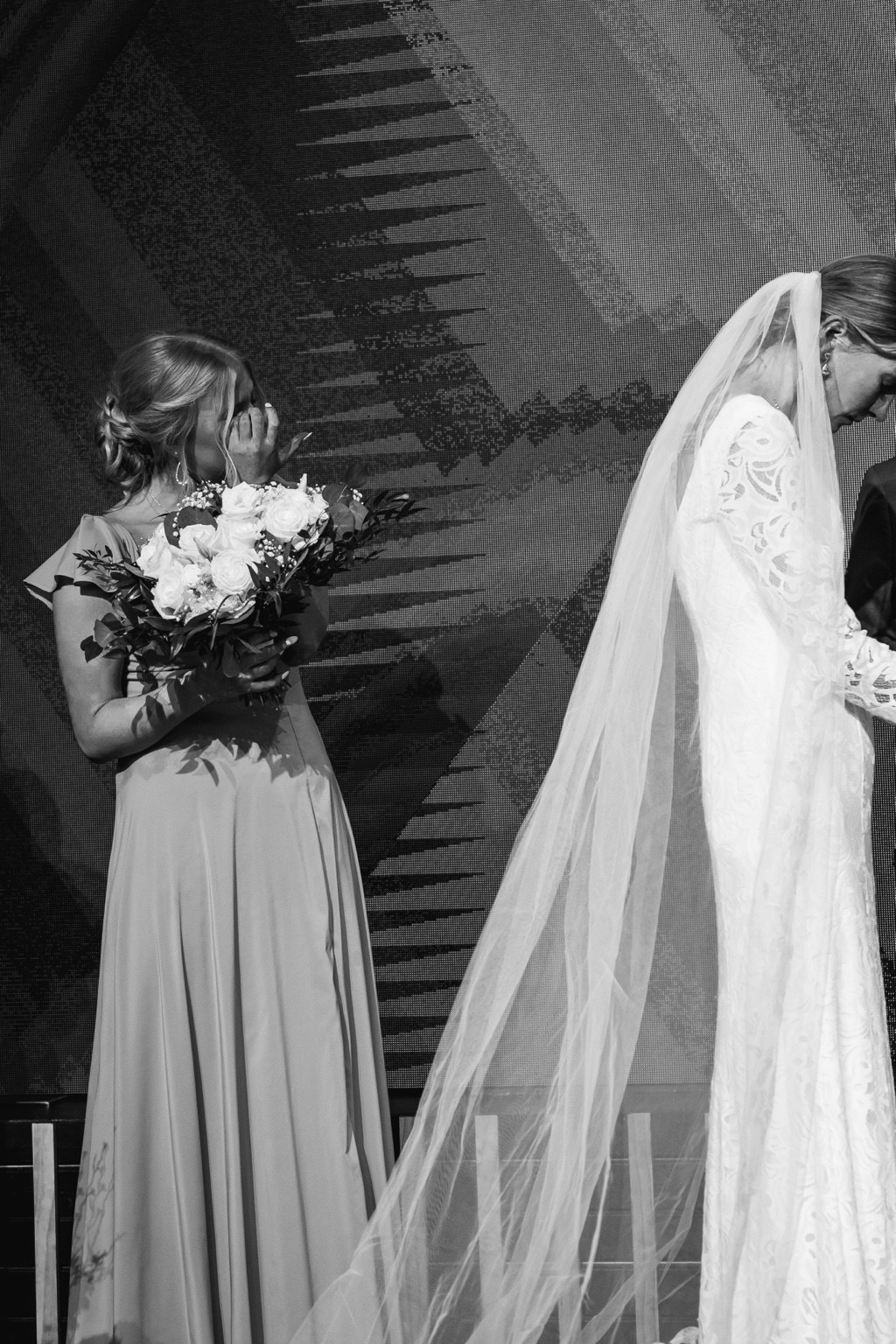 A bridesmaid wiping a tear during the wedding ceremony