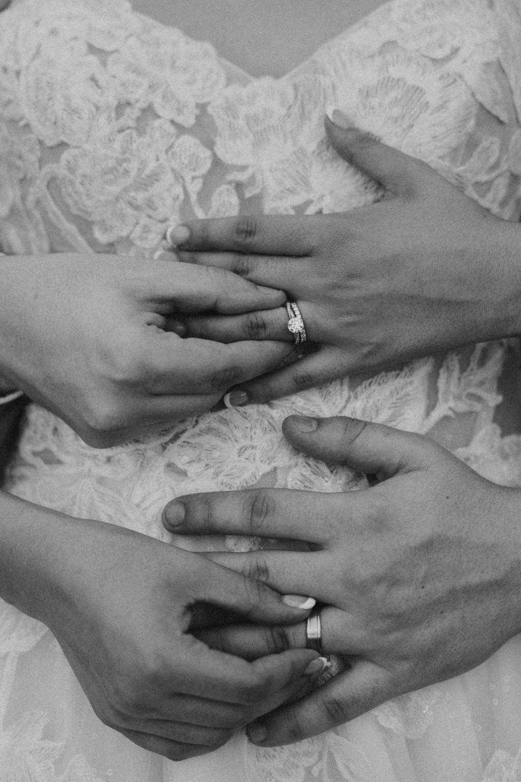 Black and white close-up of hands and wedding rings