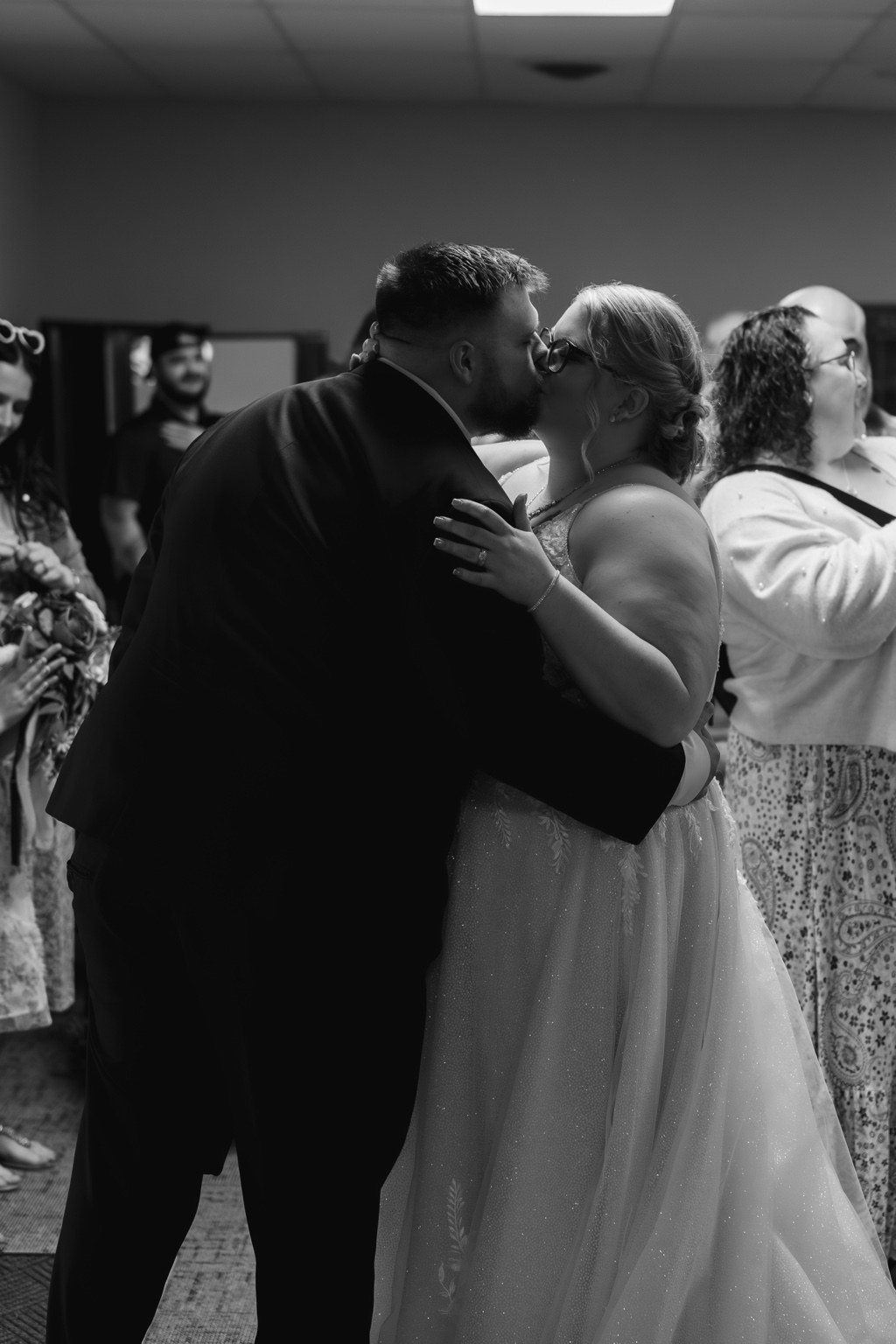 Black and white photograph of a couple kissing during their dance