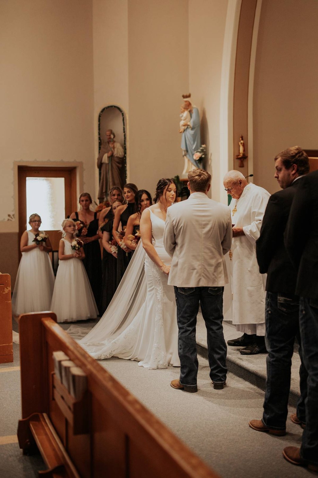 The wedding party gathered beside a couple during their vows