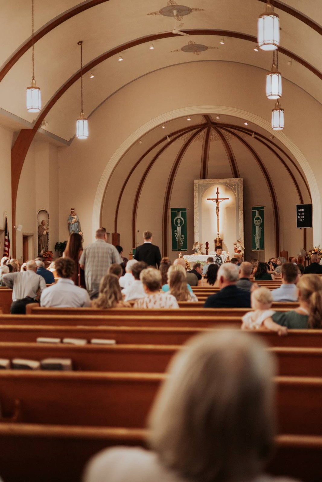 Wedding guests gathered beneath the arched ceiling of a church